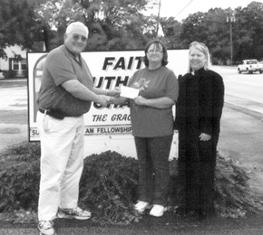 David Vorpagel and Pastor Cathy Harris of Faith Lutheran Church present a check to Esther Corn of The Gleaning House.