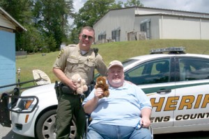 Dr. J.W. Stansell presents a Pickens County Sheriff’s Office deputy with teddy bears Gospel Lighthouse Prison Evangelism collected for children.