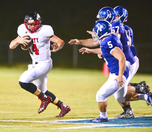 John Bolton/BoltonPhoto.com A trio of Pickens defenders closes in on Liberty quarterback Austin Hughey on Friday night. The Red Devils have yet to find the end zone through the first two games of the season, including Friday’s 30-0 loss to the Blue Flame.