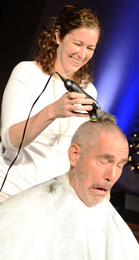 Southern Wesleyan University missions mobilizer Dave Tolan grimaces as Katherine Hanson, the university’s residence life coordinator, shaves off his hair after students, faculty and staff met his challenge to donate 525 shoeboxes for Operation Christmas Child.